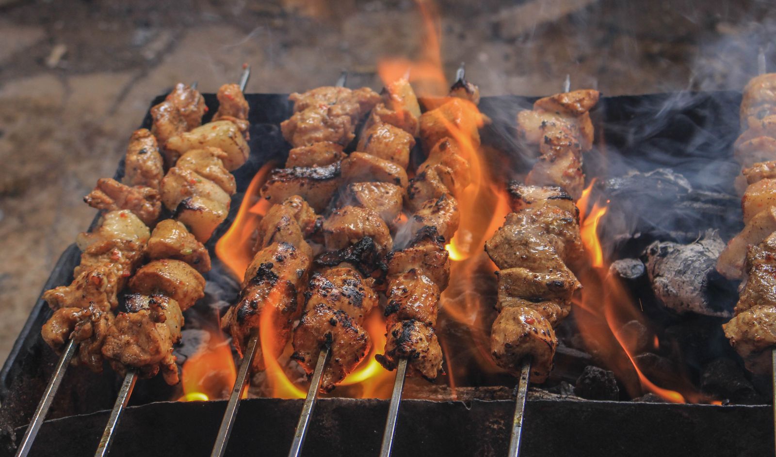 Brochettes grillées sur les braises, flammes vives